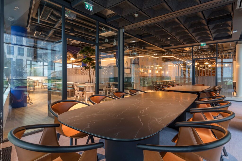 Grande table d’hôtes aux fauteuils cuivrés